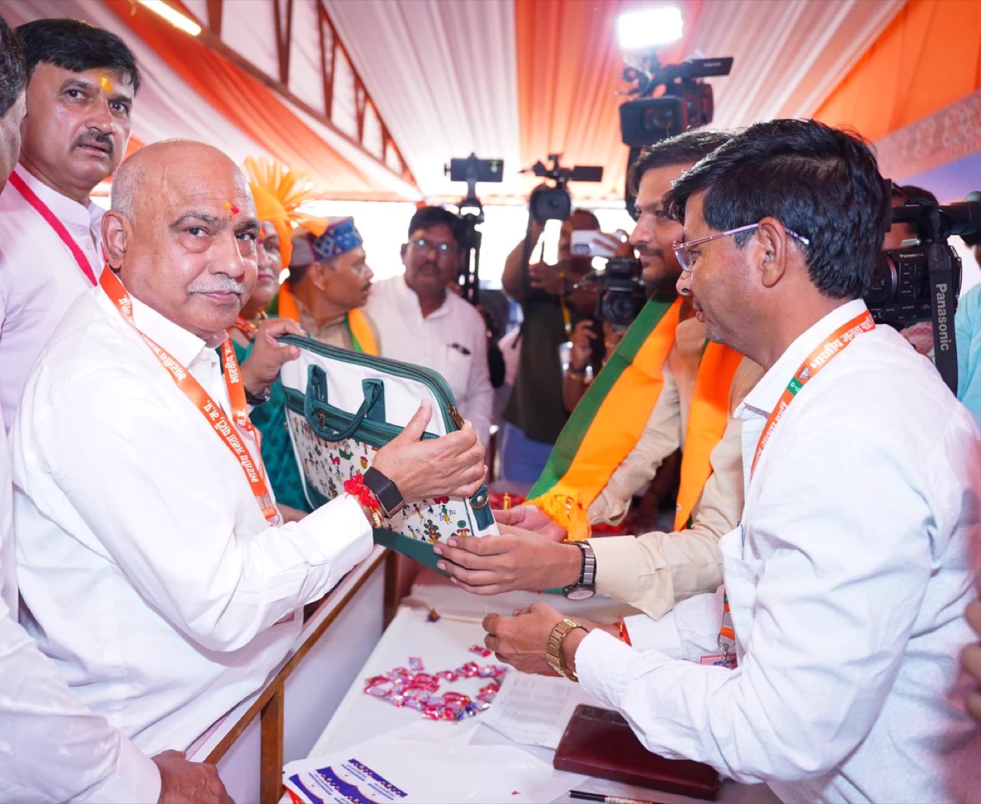Hemant Khandelwal receiving a memento from a party worker at an event