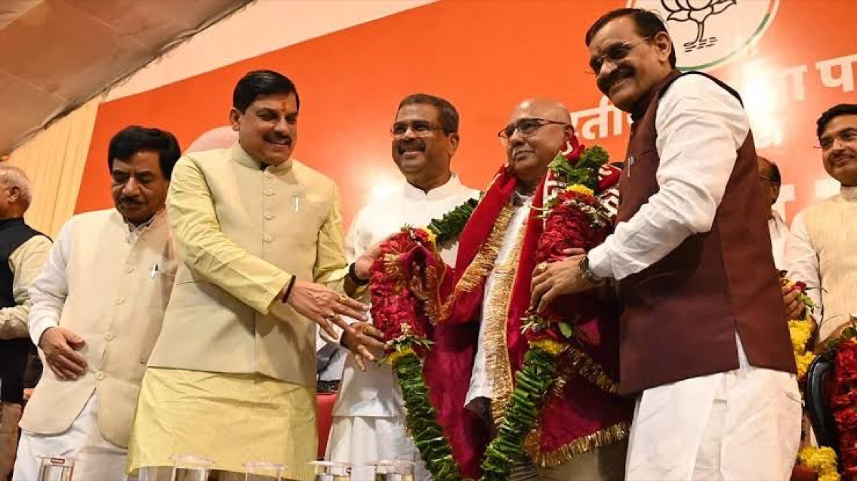 Hemant Khandelwal being felicitated with a garland on stage alongside senior leaders