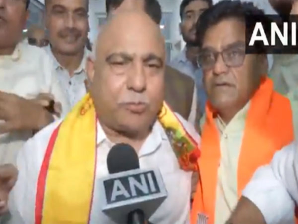 Hemant Khandelwal speaking to reporters while surrounded by party workers