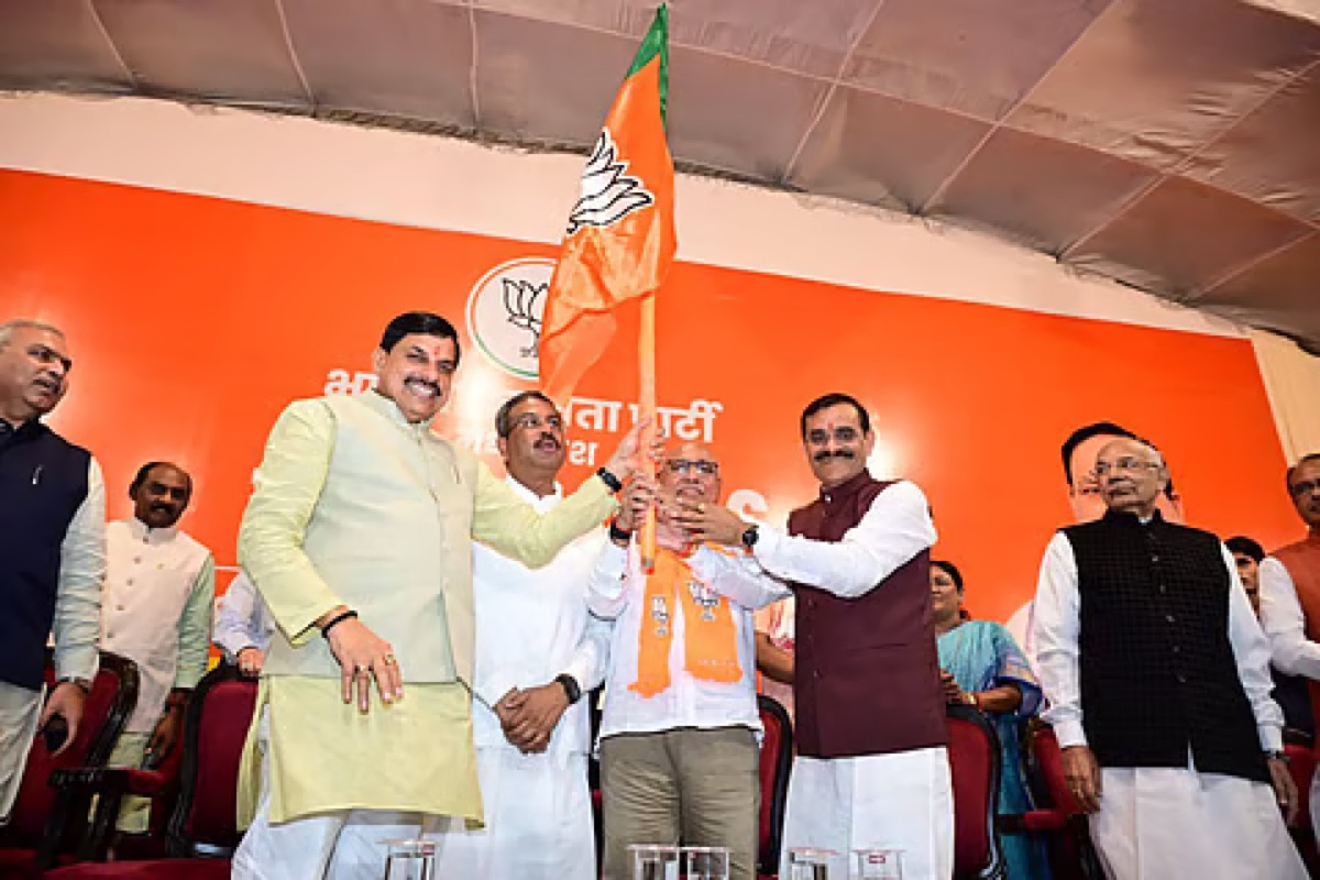 Hemant Khandelwal holding the party flag alongside senior state leaders