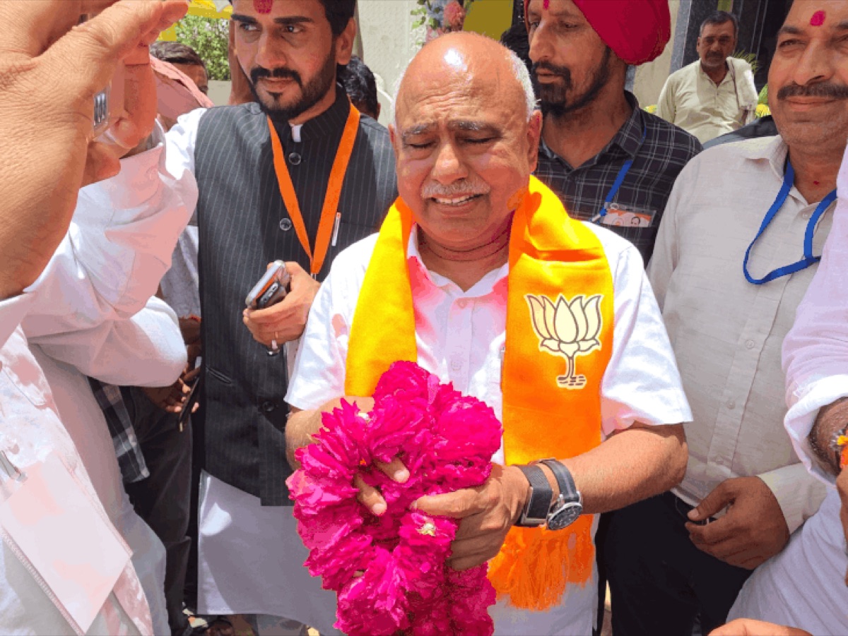 Hemant Khandelwal being welcomed by a crowd of supporters holding garlands